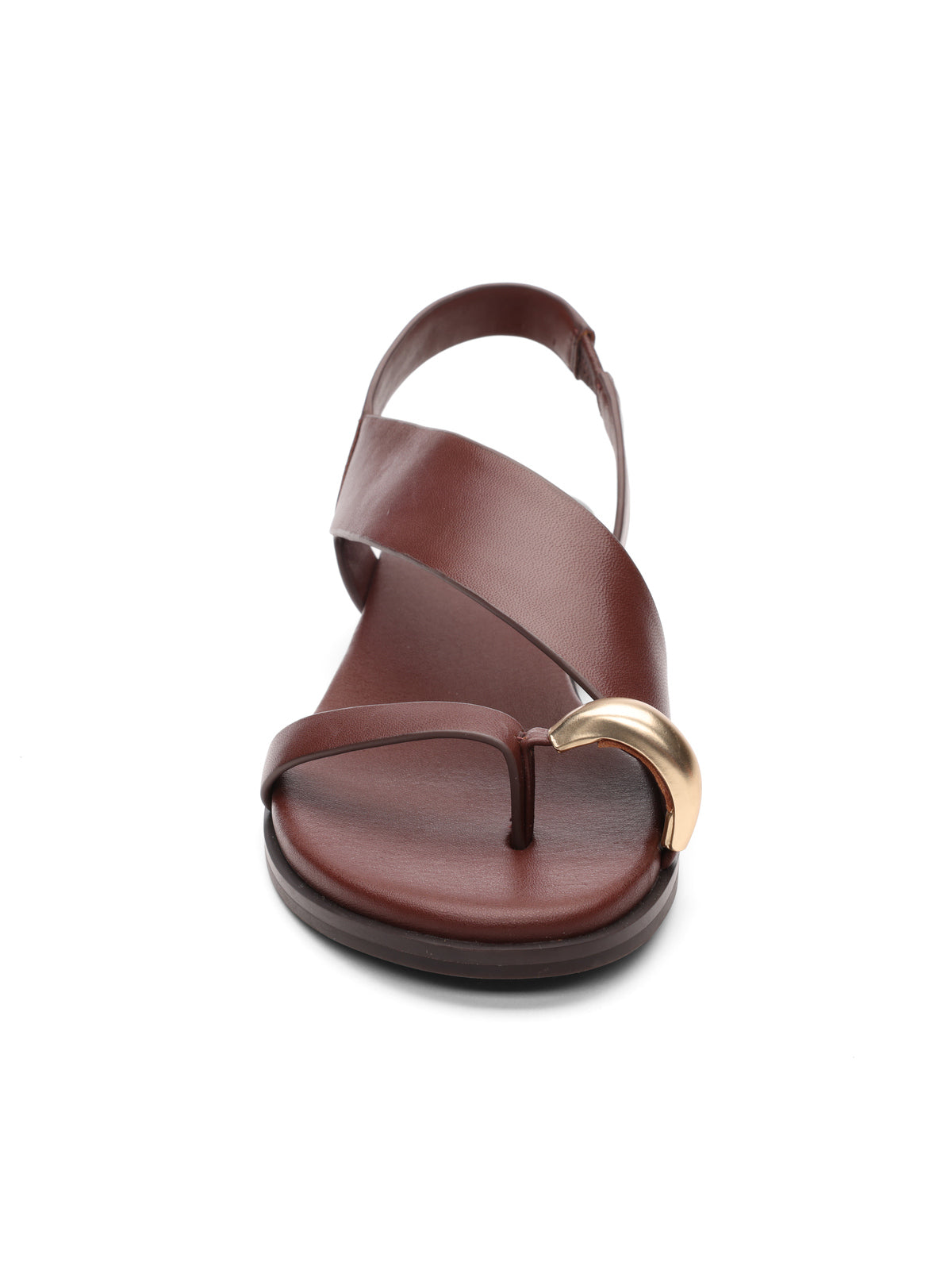 The suave toe ring sandal java by Sanctuary Clothing is a brown leather design with an asymmetrical strap featuring a gold metallic accent. This minimalist and stylish sandal includes a flat sole and toe loop for added flair.