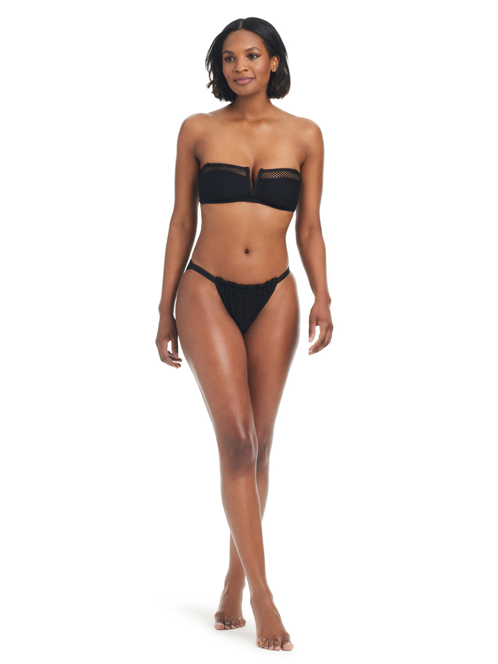 A woman with shoulder-length hair is wearing the Double Trouble V Hipster Bikini Bottom in black from Sanctuary Clothing. She is standing and posing against a plain white background, looking towards the camera with a composed expression.