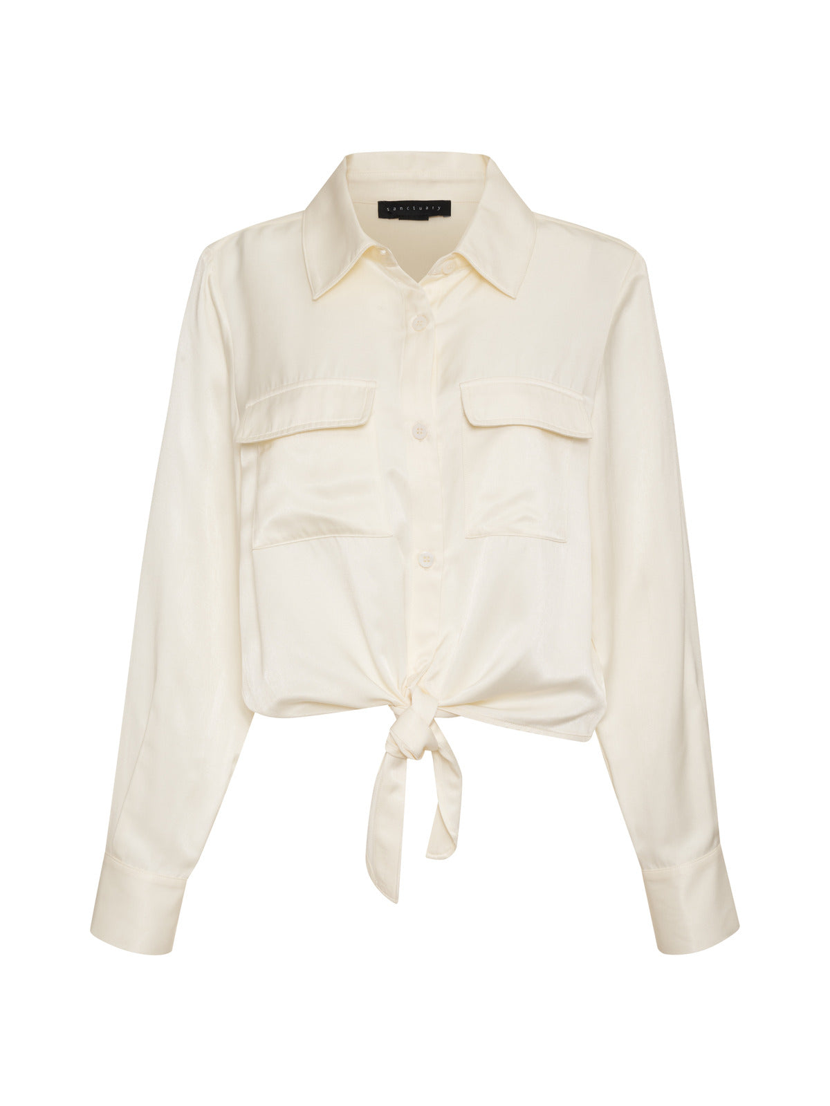 The Lifetime Shirt Chalk by Sanctuary Clothing is a light beige, long-sleeved blouse featuring a front tie knot, a button-up closure, and two chest pockets. It has a collared neckline and cuffed sleeves, making it ideal for both casual and semi-formal wear.