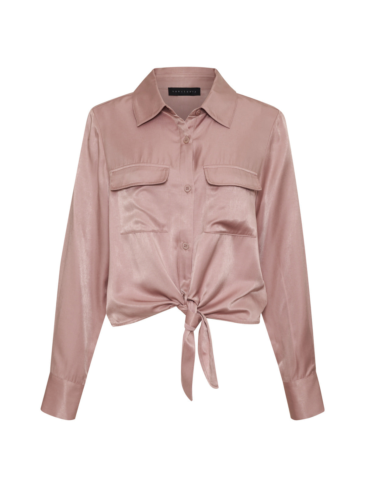 Introducing the Sanctuary Clothing Lifetime Shirt in Smokey Rose, a long-sleeved, silky blouse in a soft blush pink color. It features a classic collar, two front chest pockets, and a tie-front design at the waist, with buttons running down the front for closure.