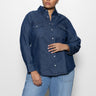 A person wearing the Sanctuary Clothing denim western shirt blue slate inclusive collection stands against a plain white background, with their right hand on their hip while looking slightly to the left, paired with light blue jeans.