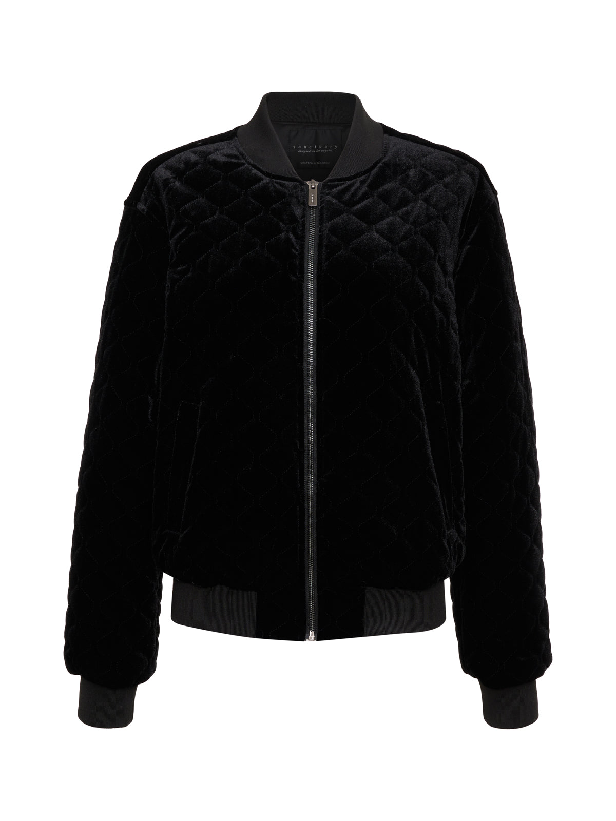 The Mona Velvet Bomber by Sanctuary Clothing is a black quilted jacket with long sleeves and a front zipper. It features ribbed cuffs and waistband, showcasing a minimalist, elegant design.