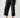 A person is wearing the Cali Cargo Pant Black by Sanctuary Clothing, featuring multiple pockets and rolled up to mid-calf length. They are also sporting black ankle-strap sandals, with a partially visible white top. The background is plain and light-colored.