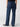 A person is wearing the Sanctuary Clothing Marine Full Length Aspen, which are high-waisted blue jeans with flared legs, paired with a black top. Seen from the back, the person is standing and wearing black shoes against a plain white background.