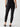 A person wearing the black "Pucker Up Runway Legging" by Sanctuary Clothing paired with black flat shoes is standing with their back facing the camera. The ankle-length leggings feature a sheer patterned design below the knee, all set against a plain white background.