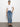 A person stands against a plain white background wearing the 'Sculpted Hayden Straight Crop Best in Show' jeans by Sanctuary Clothing, paired with a white T-shirt and black slip-on shoes. Their left hand rests in their pocket as they look directly at the camera.