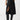 A person wearing the Classic Slit Skirt Black by Sanctuary Clothing, featuring a front slit and convenient pockets, paired with matching black knee-high boots. The individual is striking a pose with one hand tucked into a pocket, set against a plain white background.