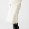 A person is shown wearing the "Essential Cargo Skirt" in French Vanilla by Sanctuary Clothing, which features large side pockets and a button-up front. They are also wearing a light-colored top and black pointed-toe boots, with a plain white background.