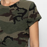 A person is wearing Sanctuary Clothing's "the perfect tee hiker camo" featuring a green and brown camouflage pattern. Only the shoulder, part of the chest, and arm are visible against a plain white background.