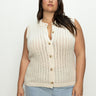 A person with long dark hair is wearing the Sanctuary Clothing 'pointelle shell eco natural inclusive collection' knit vest paired with light blue jeans. They stand against a plain light background, looking confidently at the camera.