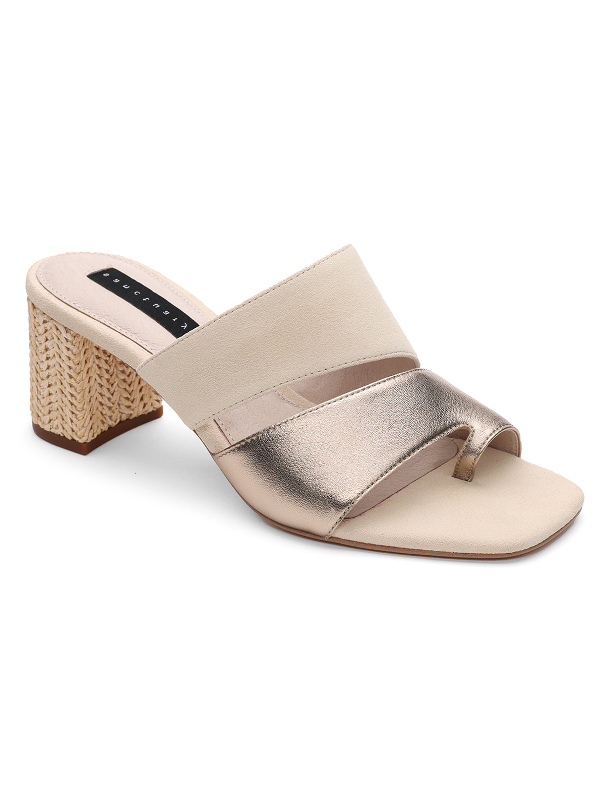 The Brisk Sandal Nude Bronze Sand Dollar by Sanctuary Clothing is a stylish sandal featuring a chunky woven block heel and an open-toe design with two straps. The upper strap is light beige suede, while the lower one exudes elegance in metallic silver. The insole appears padded for added comfort, and the distinctive heel brings a touch of uniqueness.