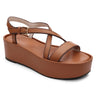 The Define Sandal Deep Honey by Sanctuary Clothing is a single platform sandal in a tan brown hue featuring a thick sole, closed heel, and crisscross straps. It also includes an adjustable ankle strap with a gold buckle and boasts a cushioned footbed for added comfort.