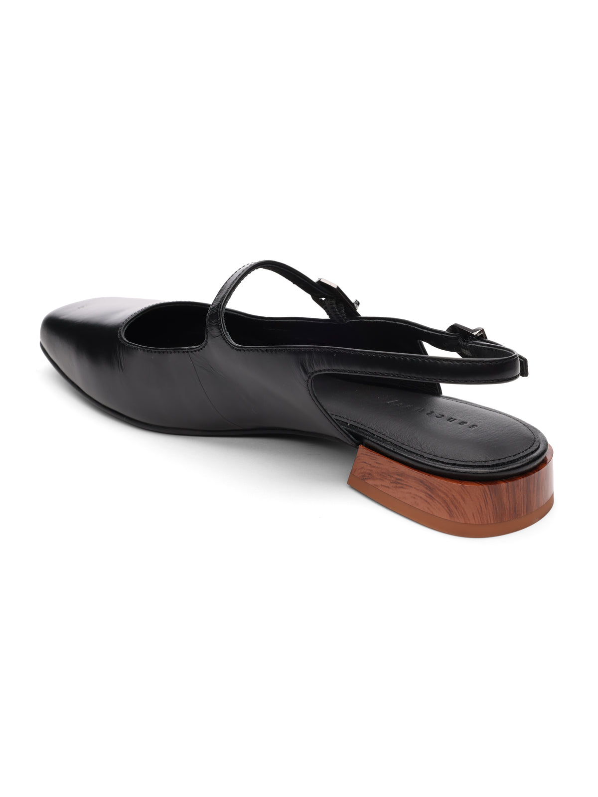 The Everly Slingback Flat Black by Sanctuary Clothing is a single black leather shoe featuring a pointed toe and an adjustable slingback strap. It showcases a unique low heel crafted from wood with a glossy finish, providing a distinct contrast to the sleek design of the upper.