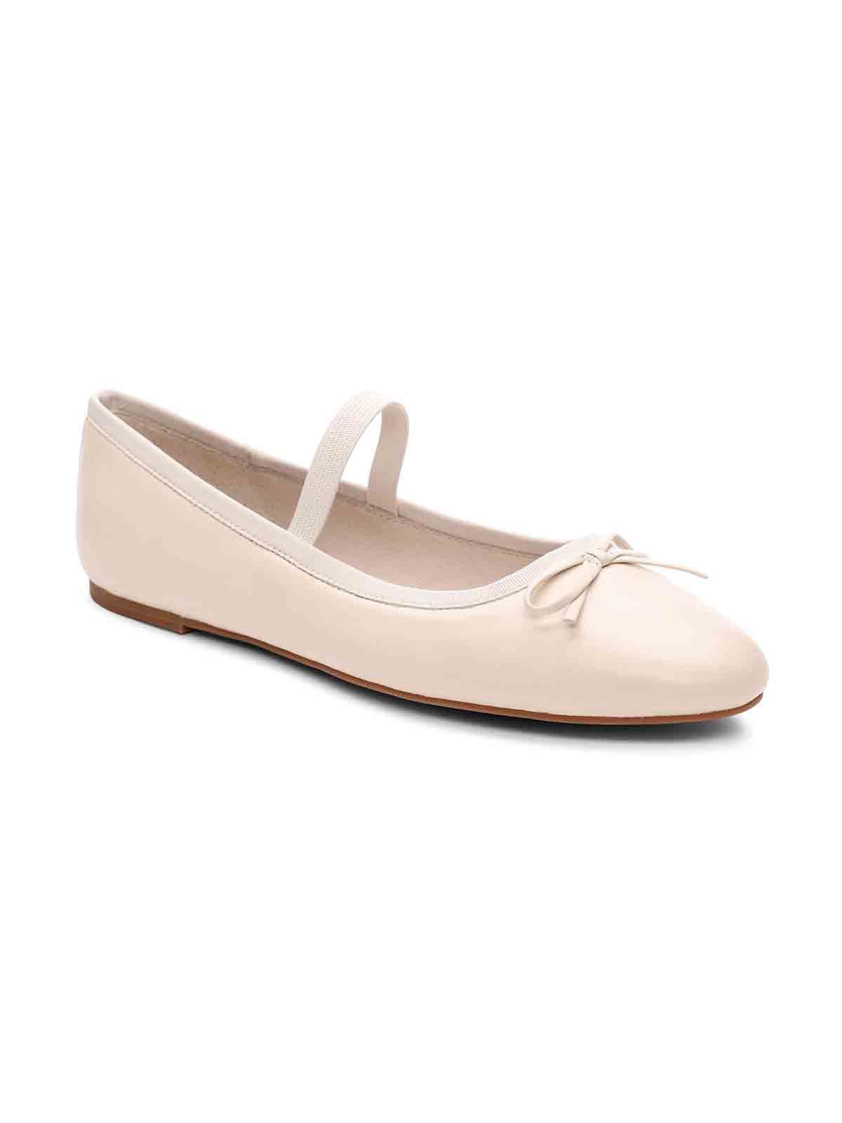 The Facile Ballet Flat Milk by Sanctuary Clothing is a single beige ballet flat featuring a small decorative bow on the front. It includes a thin elastic strap over the instep for added security. The design is simple and elegant, making it suitable for both casual and semi-formal wear.