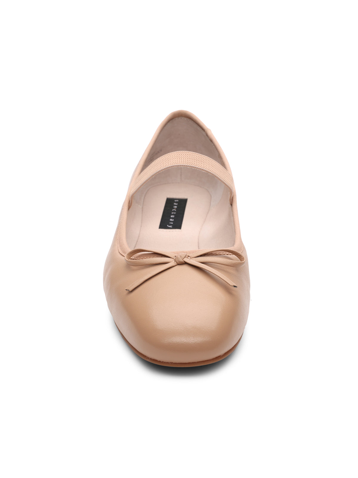 The "Facile Ballet Flat Nude" by Sanctuary Clothing is a beige ballet flat with a rounded toe, accentuated by a small bow detail on the front. The shoe's interior is light-colored and features a visible label on the insole. The shoe is displayed from a direct front view against a white background.