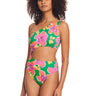 Person wearing the Super Bloom Cutout One Piece Swimsuit Multi by Sanctuary Clothing, which features a vibrant one-shoulder cutout design adorned with bold floral patterns in shades of pink, yellow, and green. The person stands confidently against a white background.