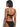 A woman is shown from the back, wearing the V Wire Bandeau Bikini Top Black by Sanctuary Clothing, featuring a textured design and a tied bow at the back of the top. She has short, dark hair and is standing against a plain, light background.