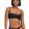 A woman with shoulder-length hair is wearing the Sanctuary Clothing V Wire Bandeau Bikini Top in black, complete with mesh details. The bikini top features a V-cutout neckline and is paired with matching bottoms. She is standing and smiling slightly.